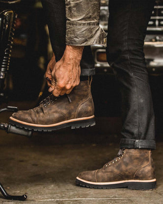 fit model tying the shoelace of The Moto Boot in Espresso Grizzly