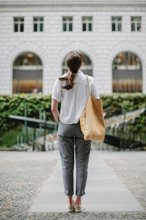 Modelling the pants - yellow tote bag over shoulder, rear view.