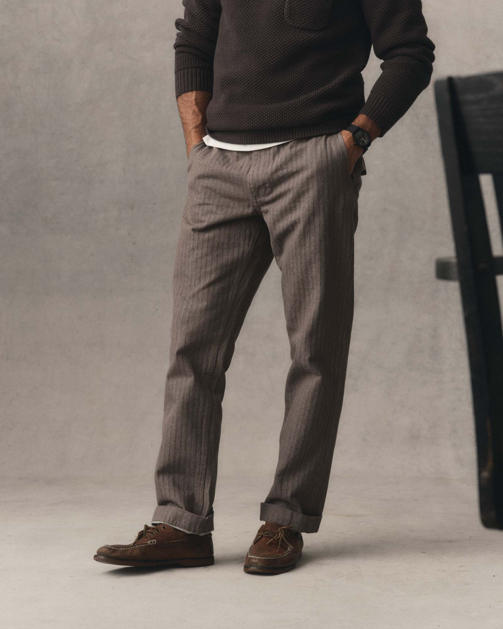 fit model posing in The Emlen Pant in Smoked Olive Herringbone, Bottoms by Taylor Stitch