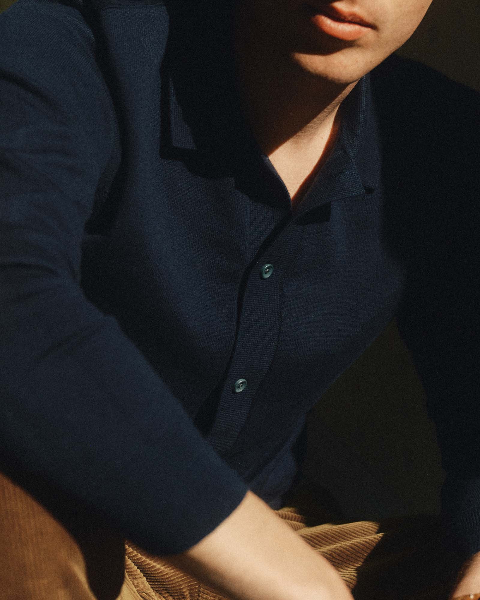 fit model sitting wearing The Nichols Polo in Nocturne Cotton Cashmere, Knits by Taylor Stitch