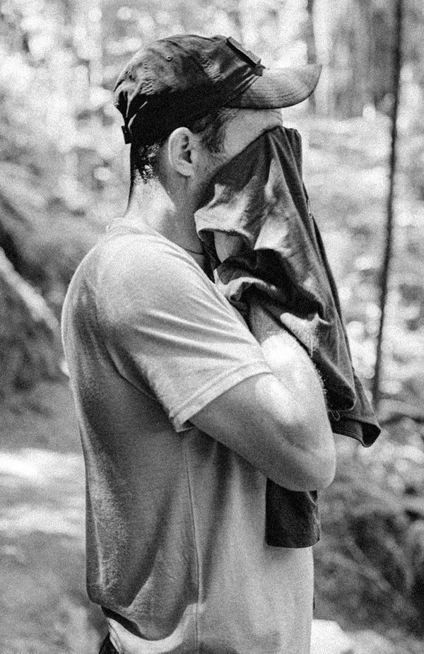 Michael wiping his face with a towel while on a hike