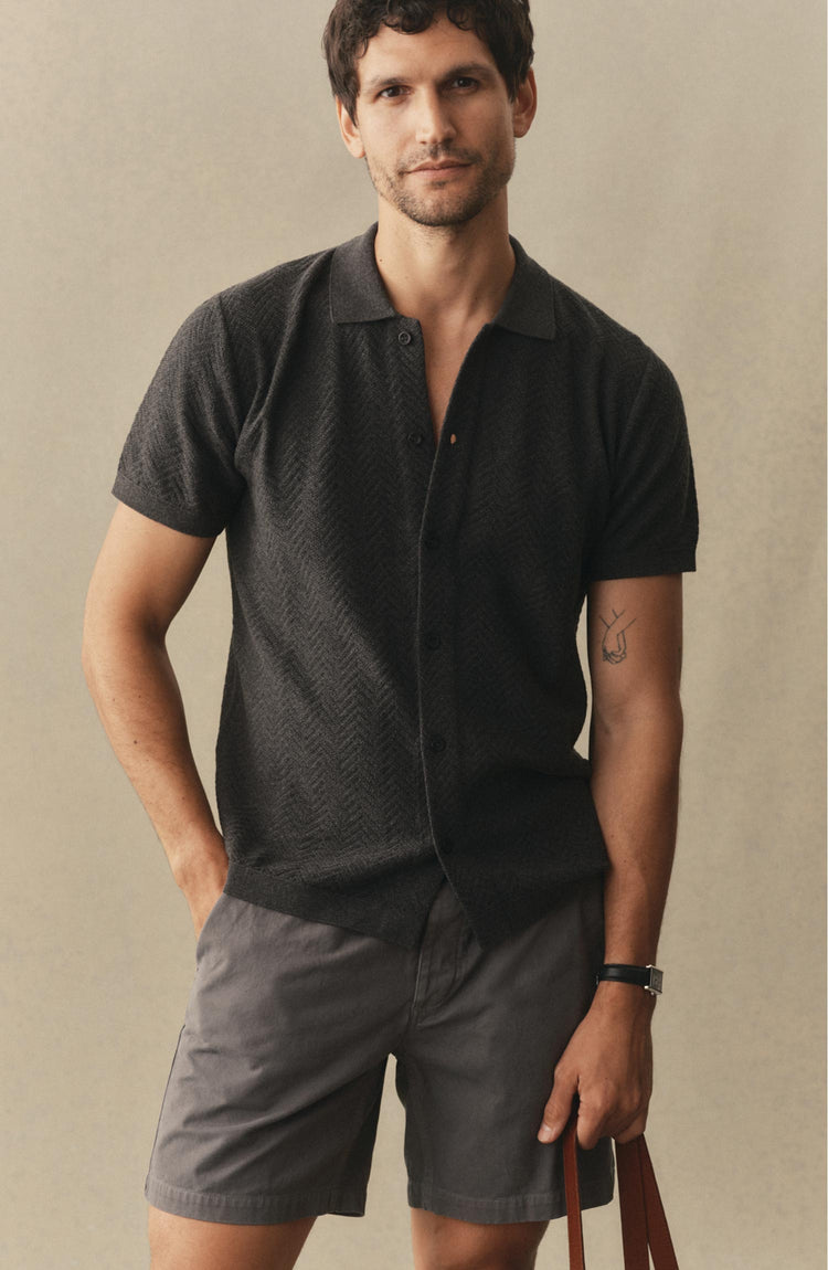 fit model posing in The Button Down Polo in Charcoal Herringbone
