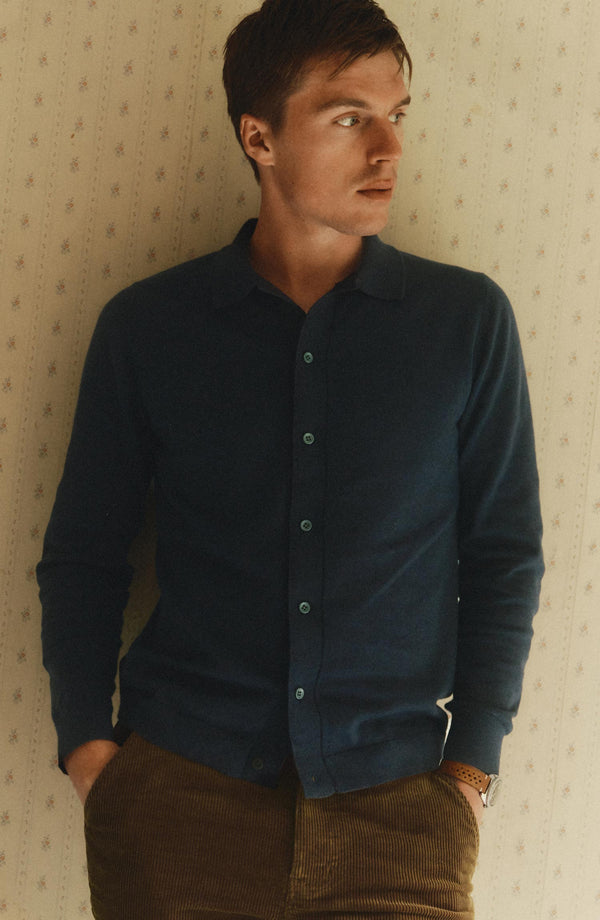 fit model leaning against the wall wearing The Nichols Polo in Nocturne Cotton Cashmere
