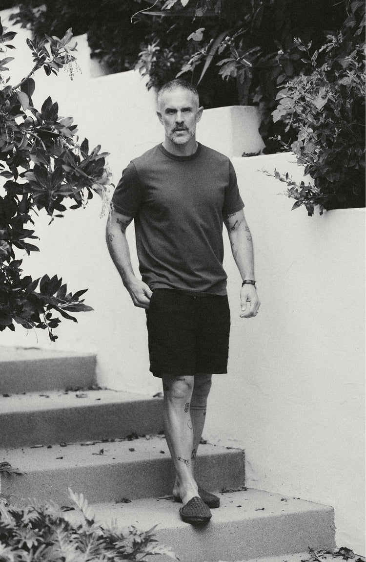 fit model posing on a rock wearing The Organic Cotton Tee in Faded Black