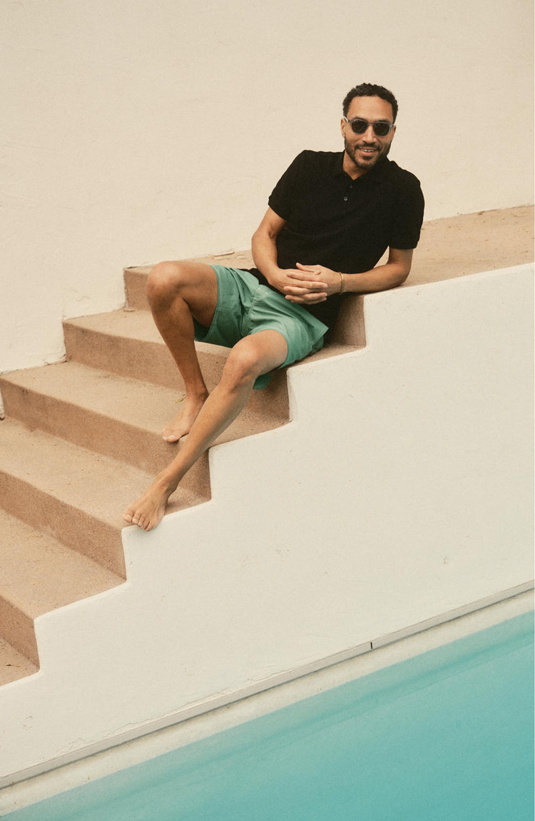 fit model posing in The Pacific Polo in Black Indigo Pique Stripe