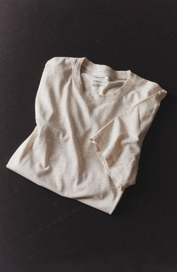 editorial flatlay of The Cotton Hemp Tee in Heather Oat folded