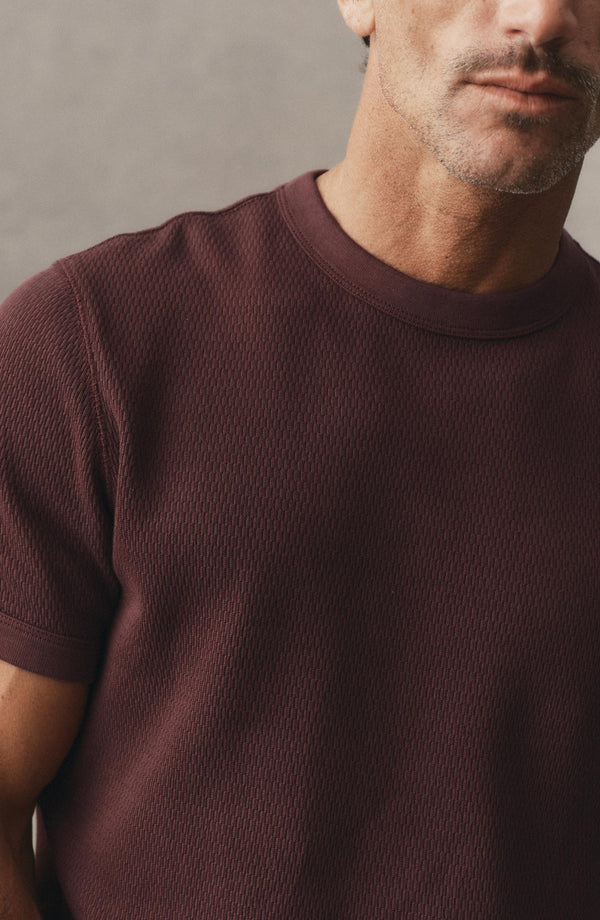 fit model sitting in a car wearing The Organic Cotton Short Sleeve Crew in Burgundy Waffle