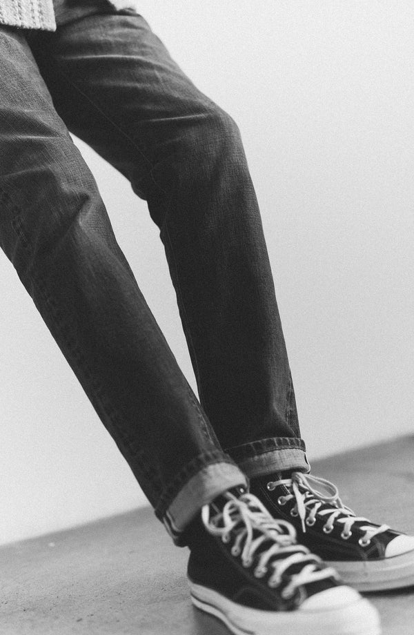 fit model showing off the back of The Slim Jean in Mid Wash Organic Selvedge