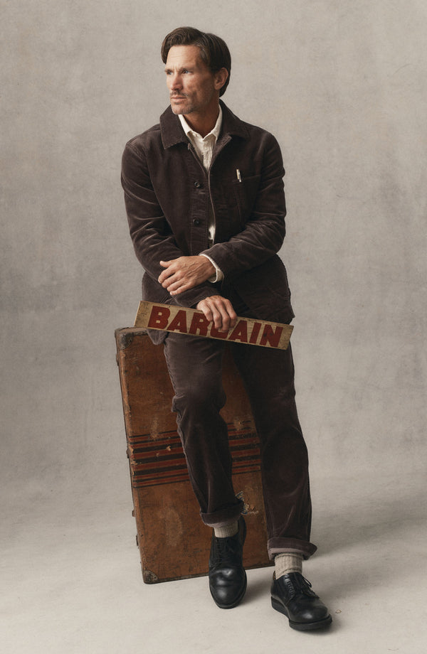 fit model sitting wearing The Carnegie Pant in Soil Corduroy