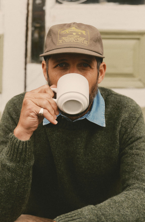 fit model sitting wearing The Eastmoor Sweater in Spruce Wool