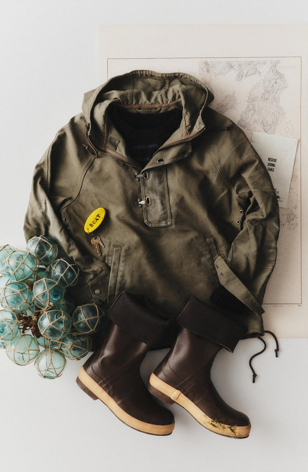 editorial flatlay of The Hatteras Anorak in Fatigue Olive Dry Wax Canvas