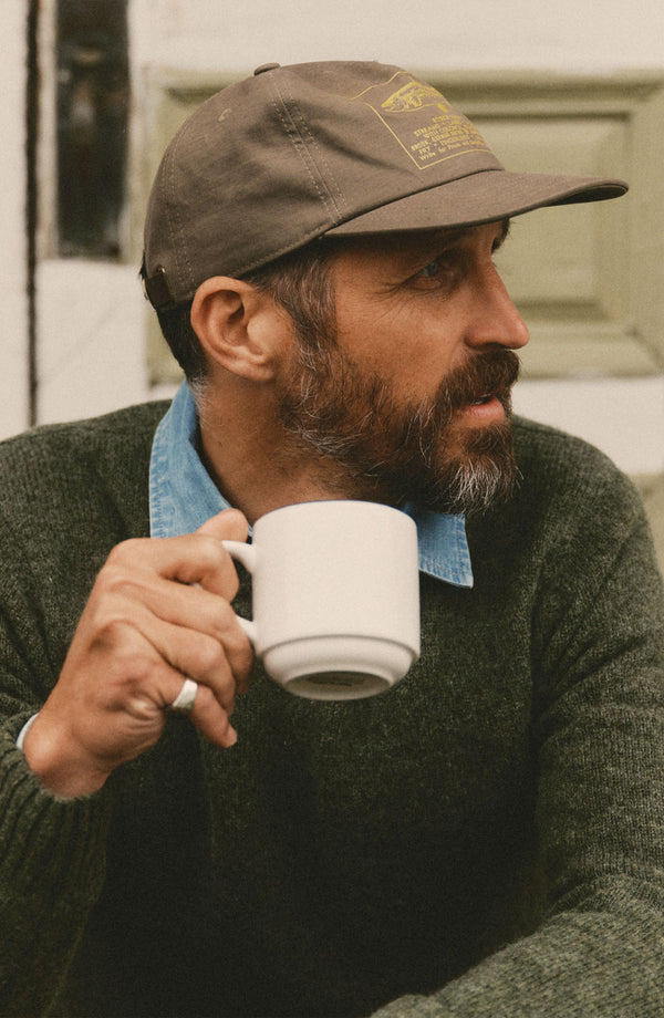 fit model sitting wearing The Mercer Cap in Fish Supply