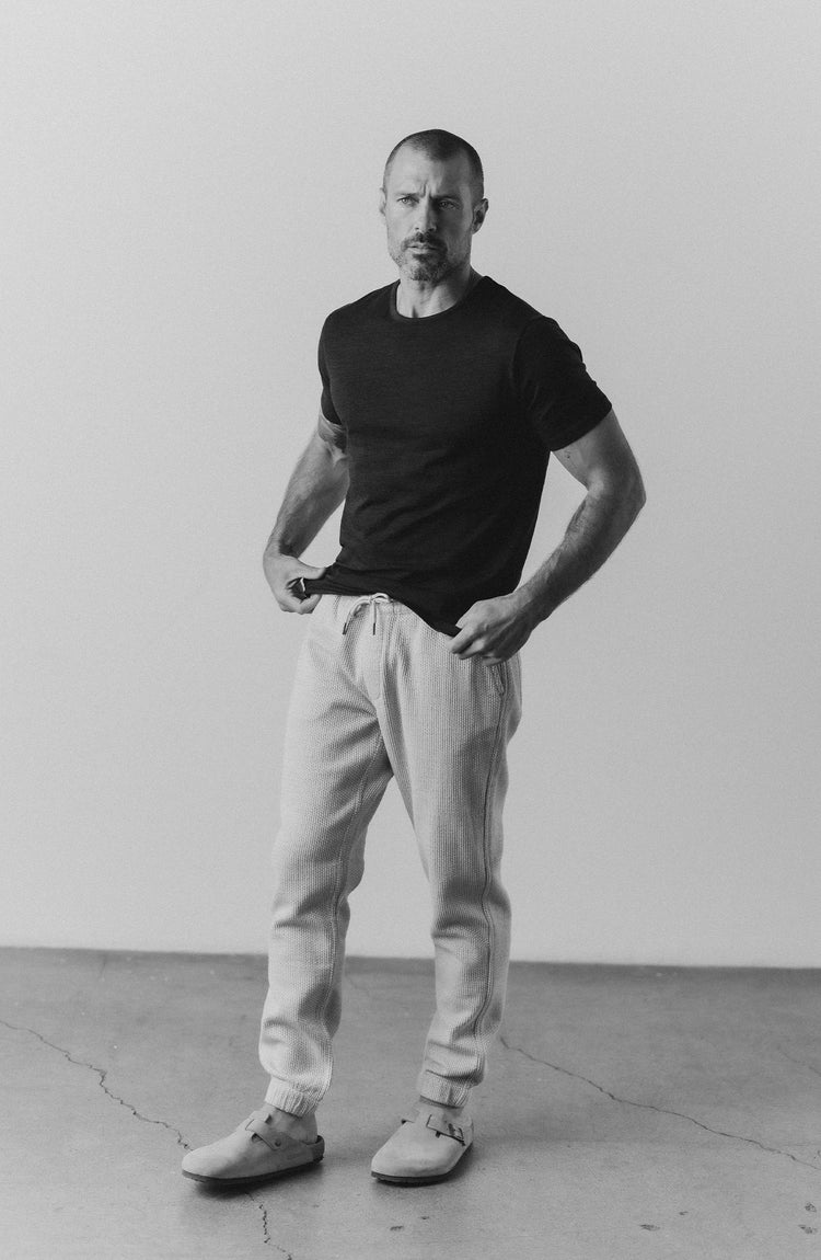 our guy rocking the merino tee near the beach—with text overlaying