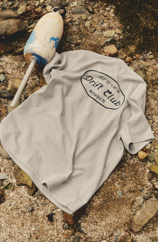 editorial flatlay of The Organic Cotton Shop Tee in Drift Club on rocks