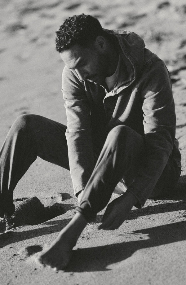 fit model sitting wearing The Roamer Pant in Smoked Olive Broken Twill