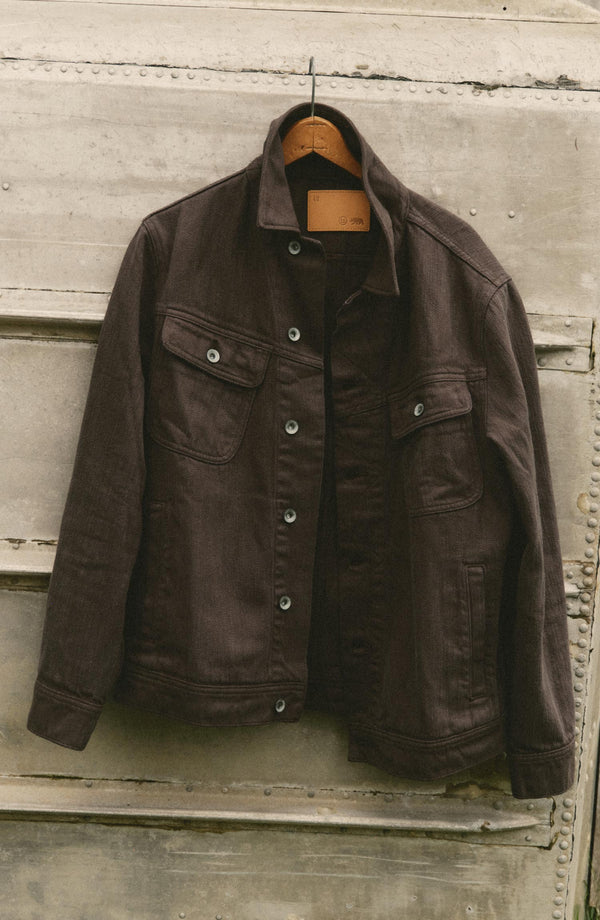 editorial image of The Long Haul Jacket in Soil Slub Denim hanging
