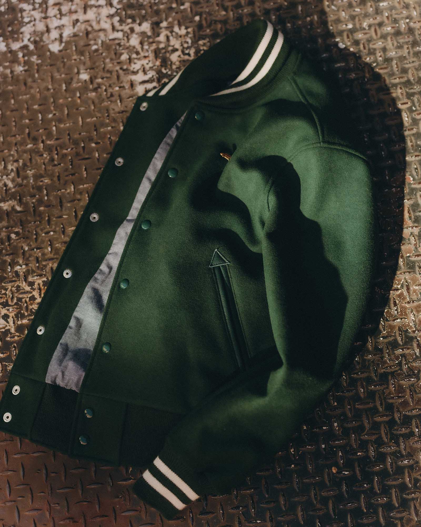editorial flatlay of The Golden Bear Snap Bomber in Ivy Wool, Outerwear by Taylor Stitch
