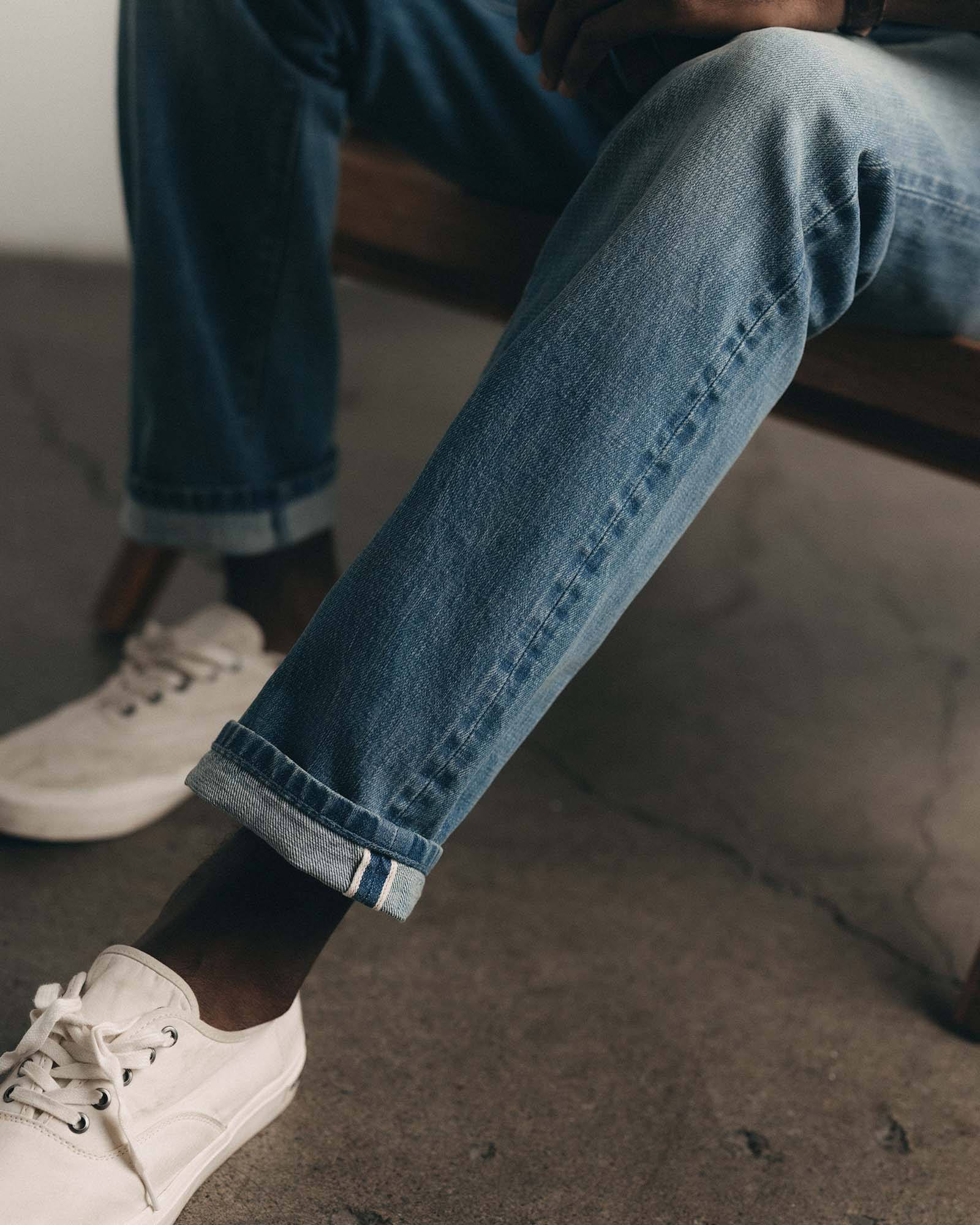 fit model sitting wearing The Straight Jean in Light Wash Organic Selvedge, Bottoms by Taylor Stitch