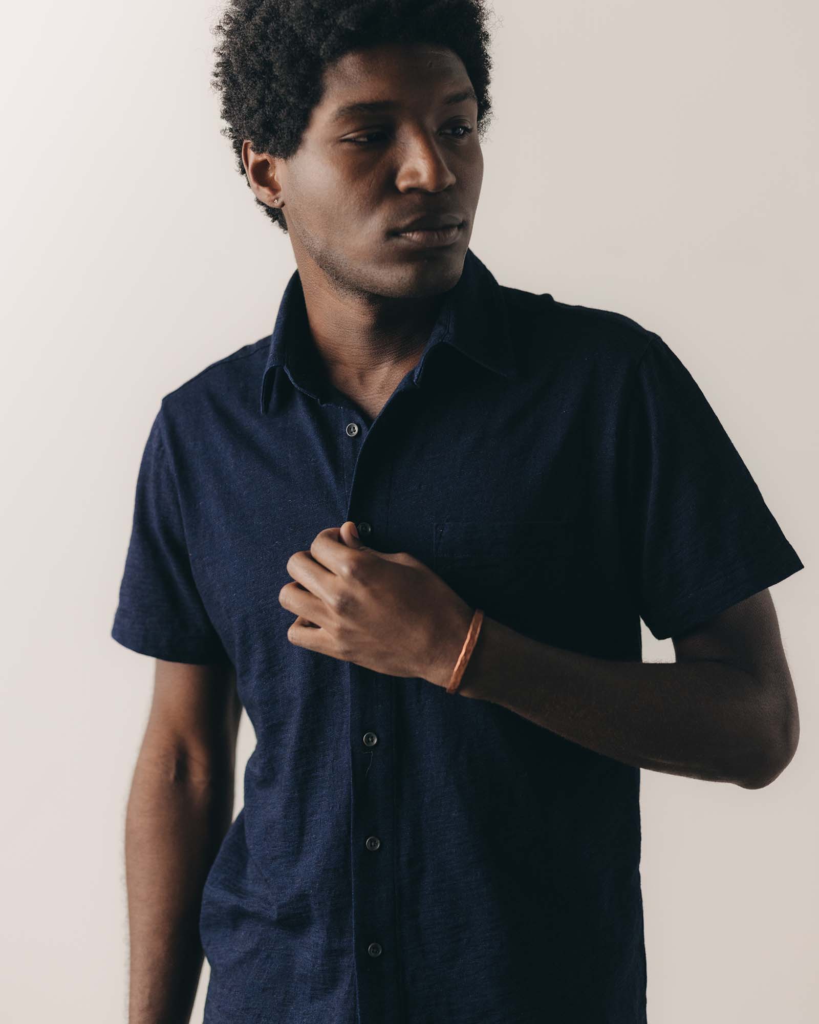 fit model sitting wearing The Short Sleeve California in Rinsed Indigo Slub, Knits by Taylor Stitch