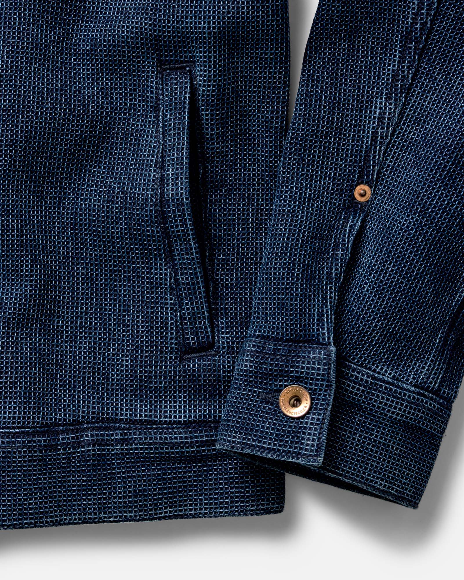The Long Haul Jacket in Rinsed Indigo Waffle hanging on the wall, Outerwear by Taylor Stitch