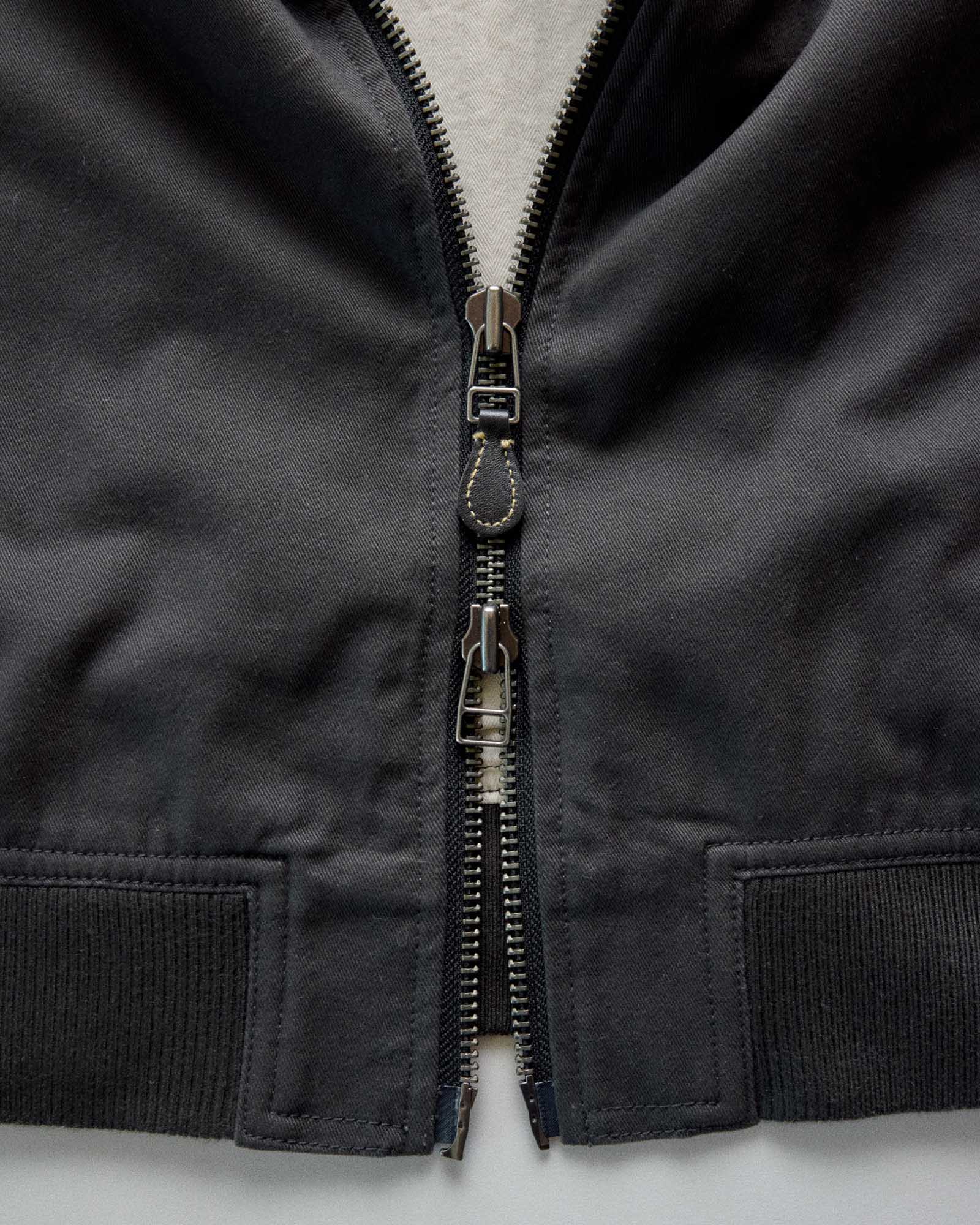 material shot of the zipper on The Speedway Bomber in Organic Faded Black Twill, Outerwear by Taylor Stitch