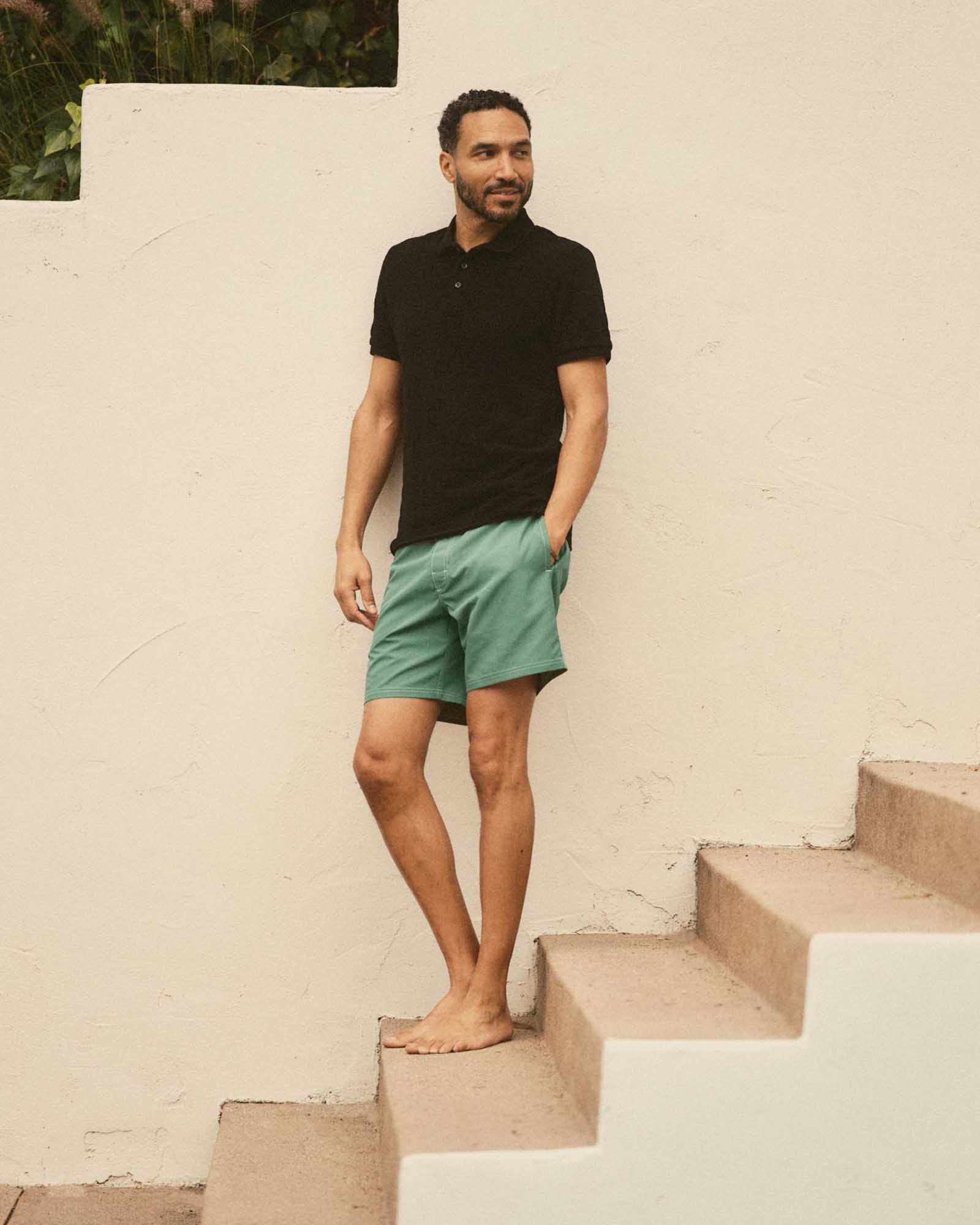 fit model leaning against the wall wearing The Pacific Polo in Black Indigo Pique Stripe, Knits by Taylor Stitch