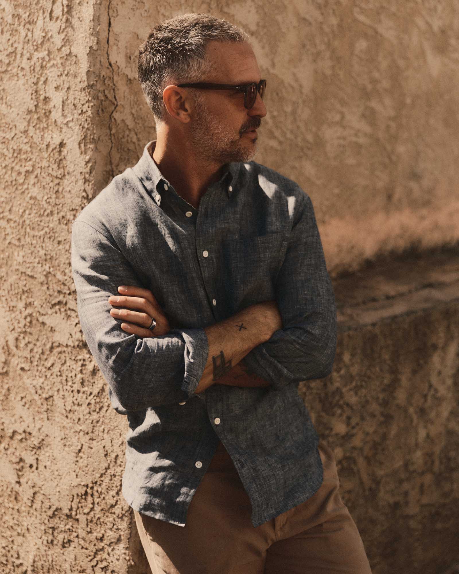 fit model leaning against the wall wearing The Jack in Ocean Linen, Wovens by Taylor Stitch