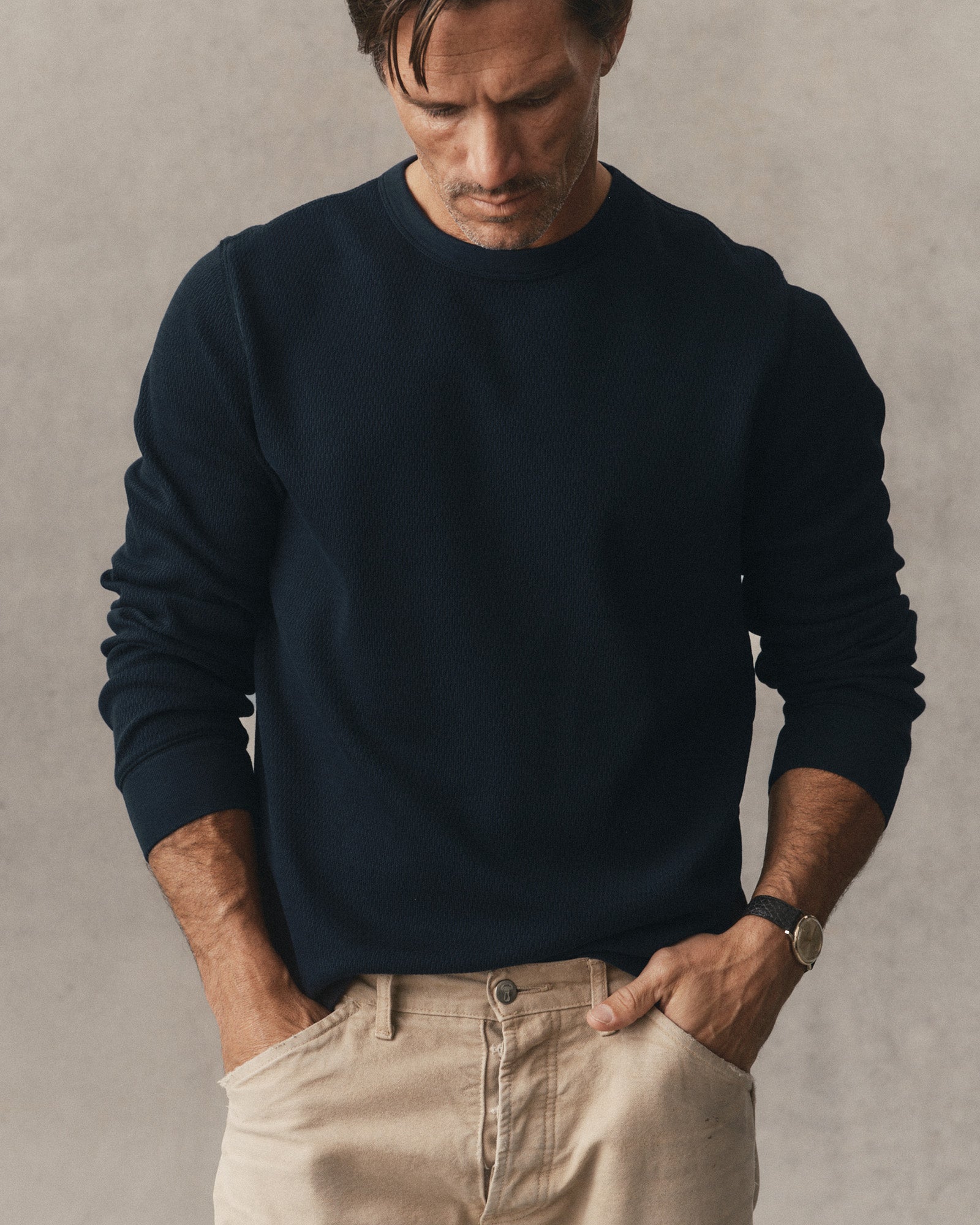 fit model leaning against a roof in The Organic Cotton Waffle Crew in Dark Navy, Knits by Taylor Stitch