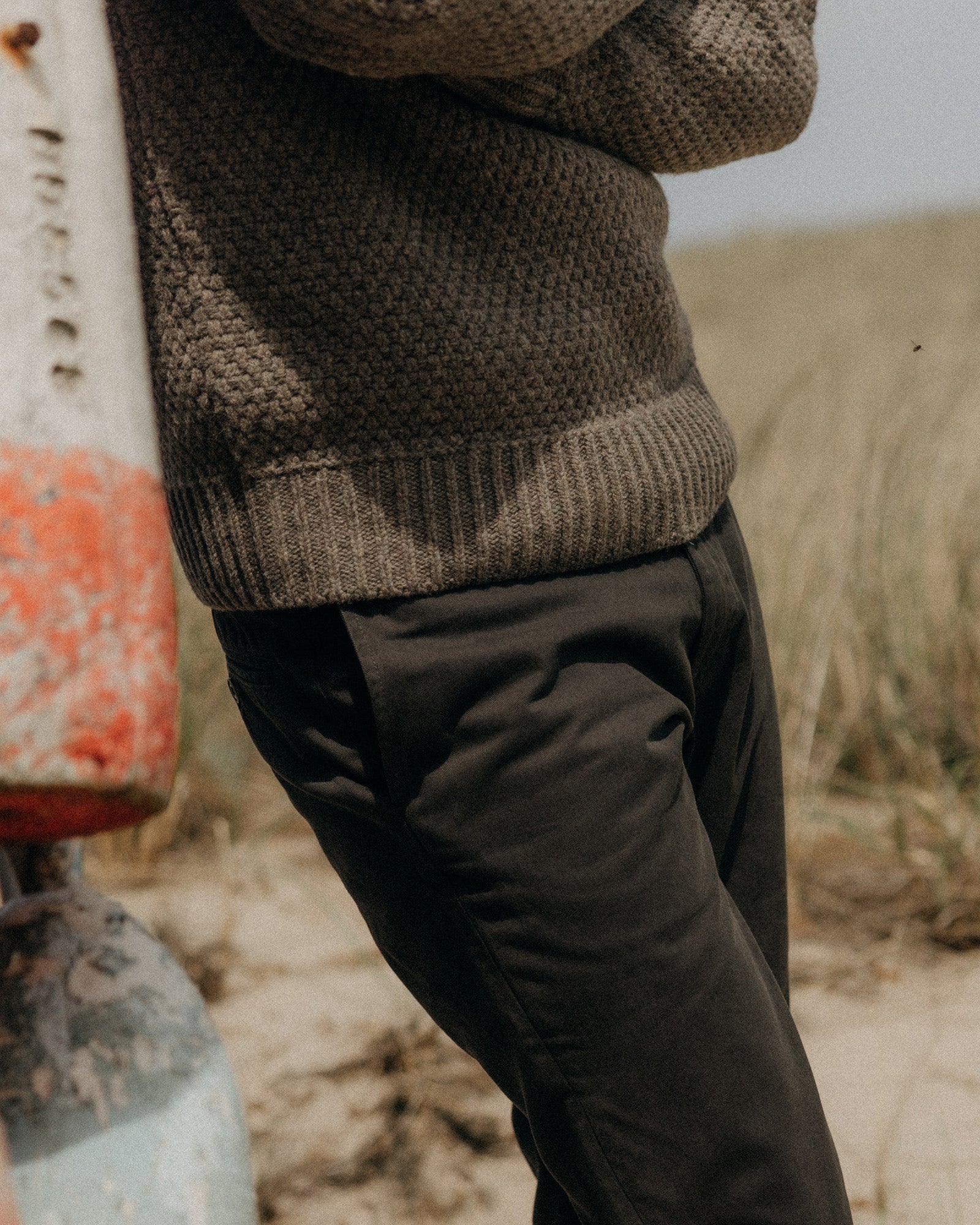 fit model standing in a field wearing The Slim Foundation Pant in Organic Faded Black, Bottoms by Taylor Stitch