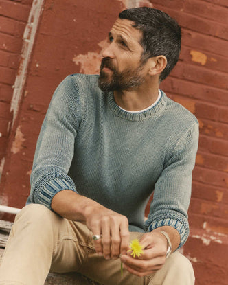 fit model sitting wearing The Dory Crew Sweater in Washed Indigo