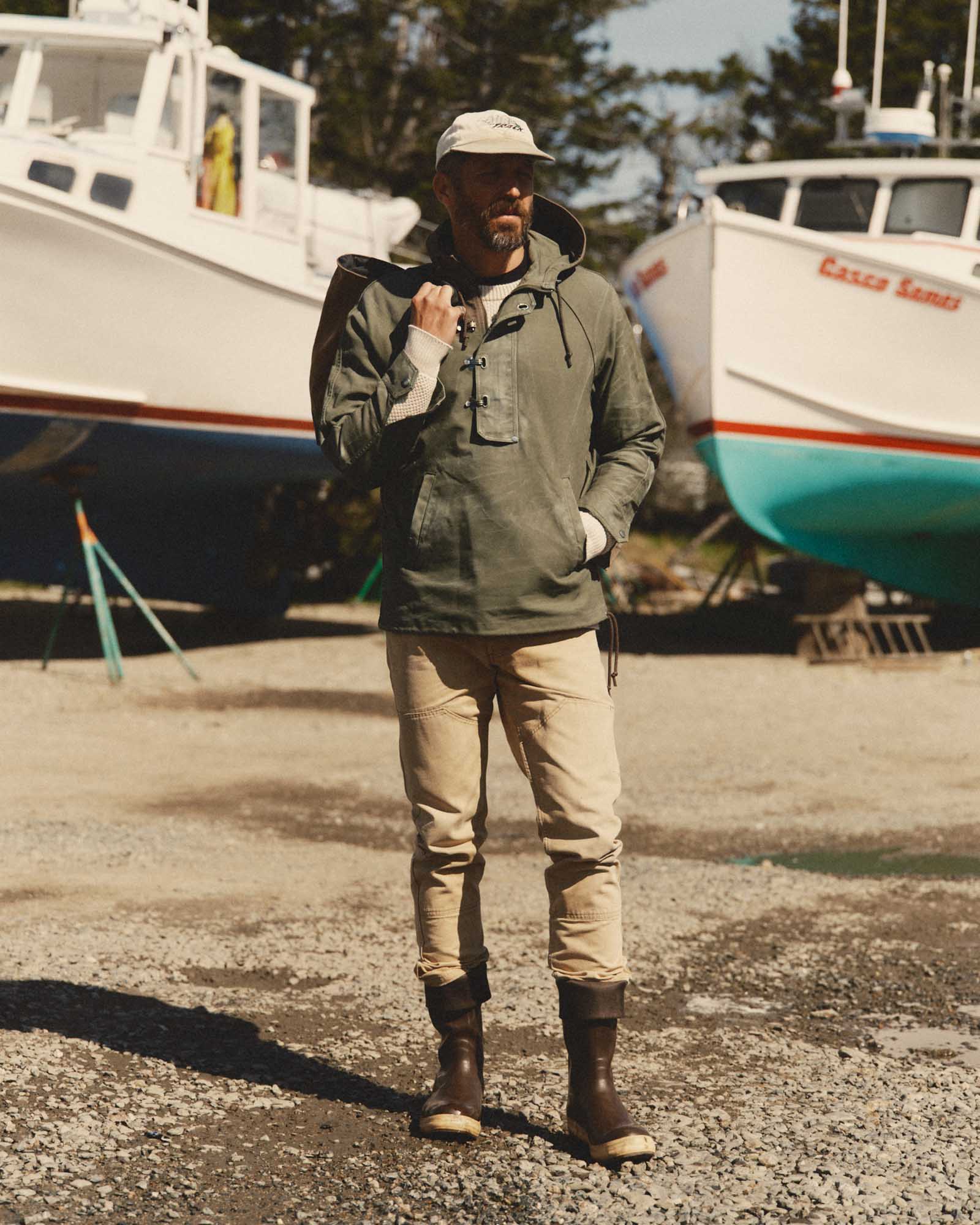 fit model walking wearing The Hatteras Anorak in Fatigue Olive Dry Wax Canvas, Outerwear by Taylor Stitch