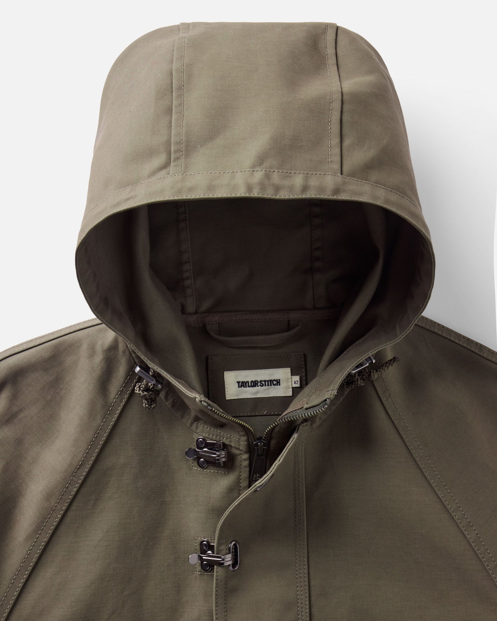 material shot of the hood on The Hatteras Anorak in Fatigue Olive Dry Wax Canvas, Outerwear by Taylor Stitch