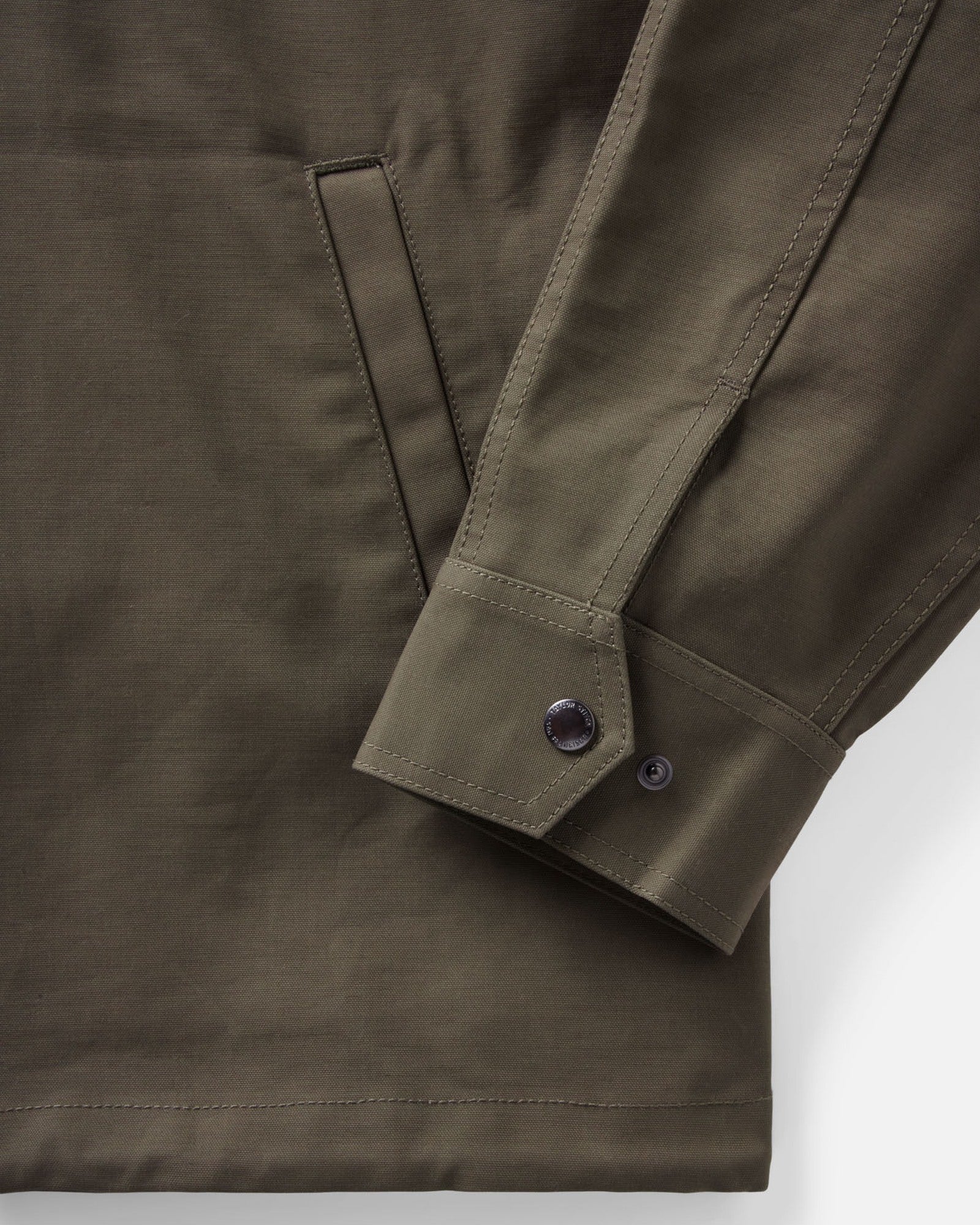 material shot of the sleeve on The Hatteras Anorak in Fatigue Olive Dry Wax Canvas, Outerwear by Taylor Stitch