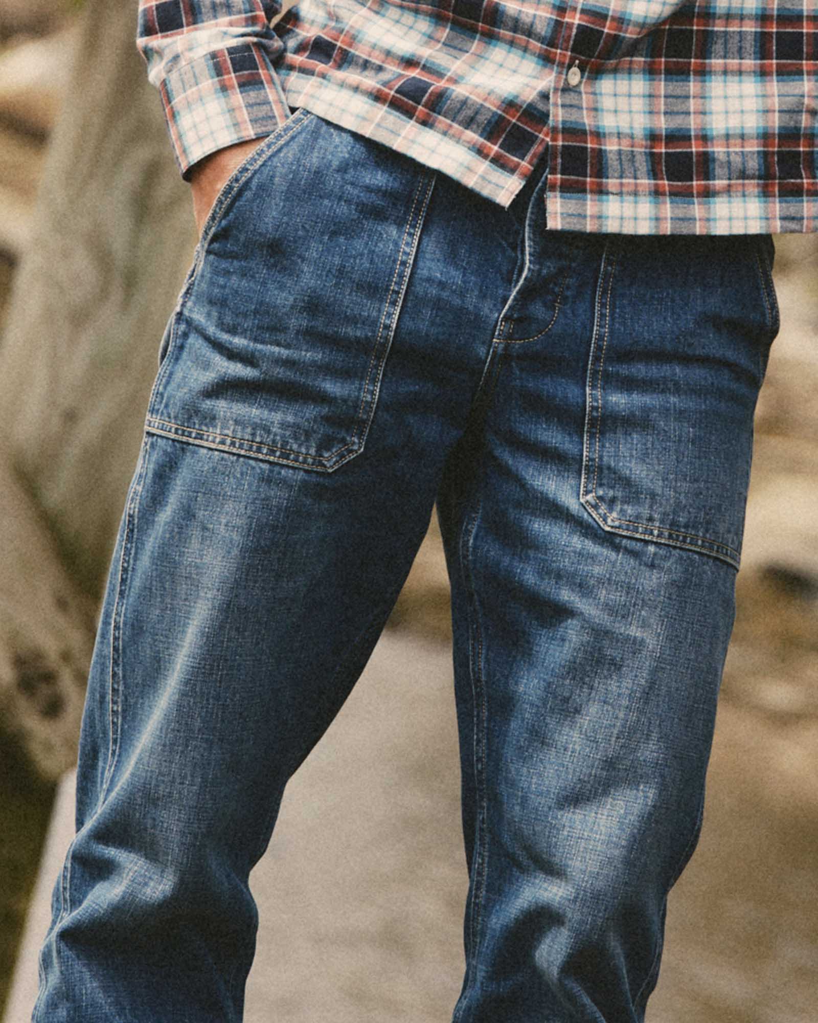 fit model with his hand in his pocket wearing The Mariner Jean in Drift Wash Organic Selvedge, Bottoms by Taylor Stitch