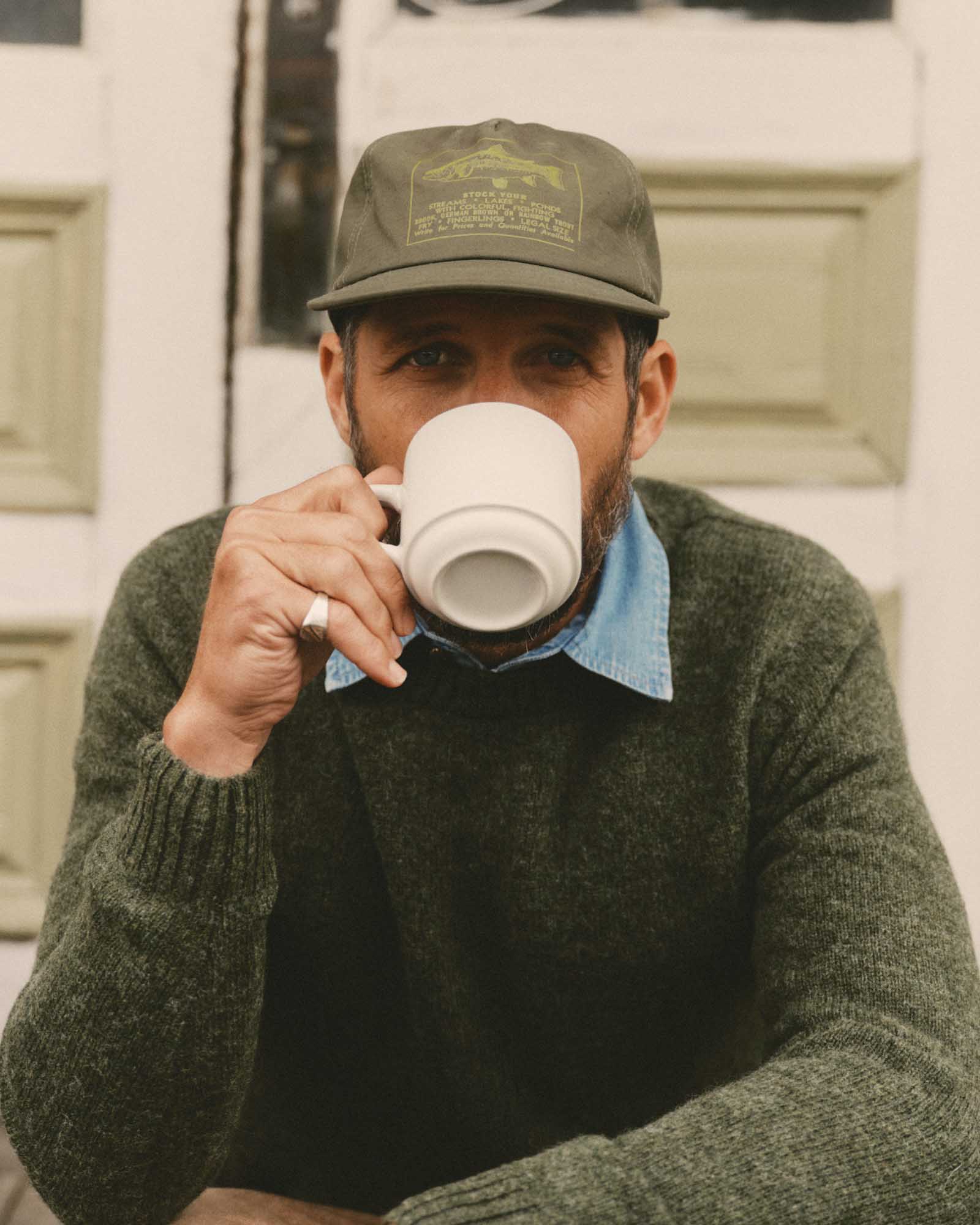 fit model sitting wearing The Mercer Cap in Fish Supply, Accessories by Taylor Stitch