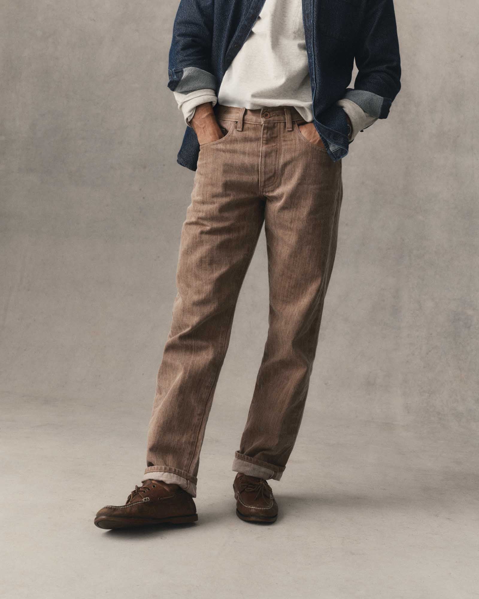 fit model with his hands in his pockets wearing The Straight Jean in Kakishibu Selvedge, Bottoms by Taylor Stitch
