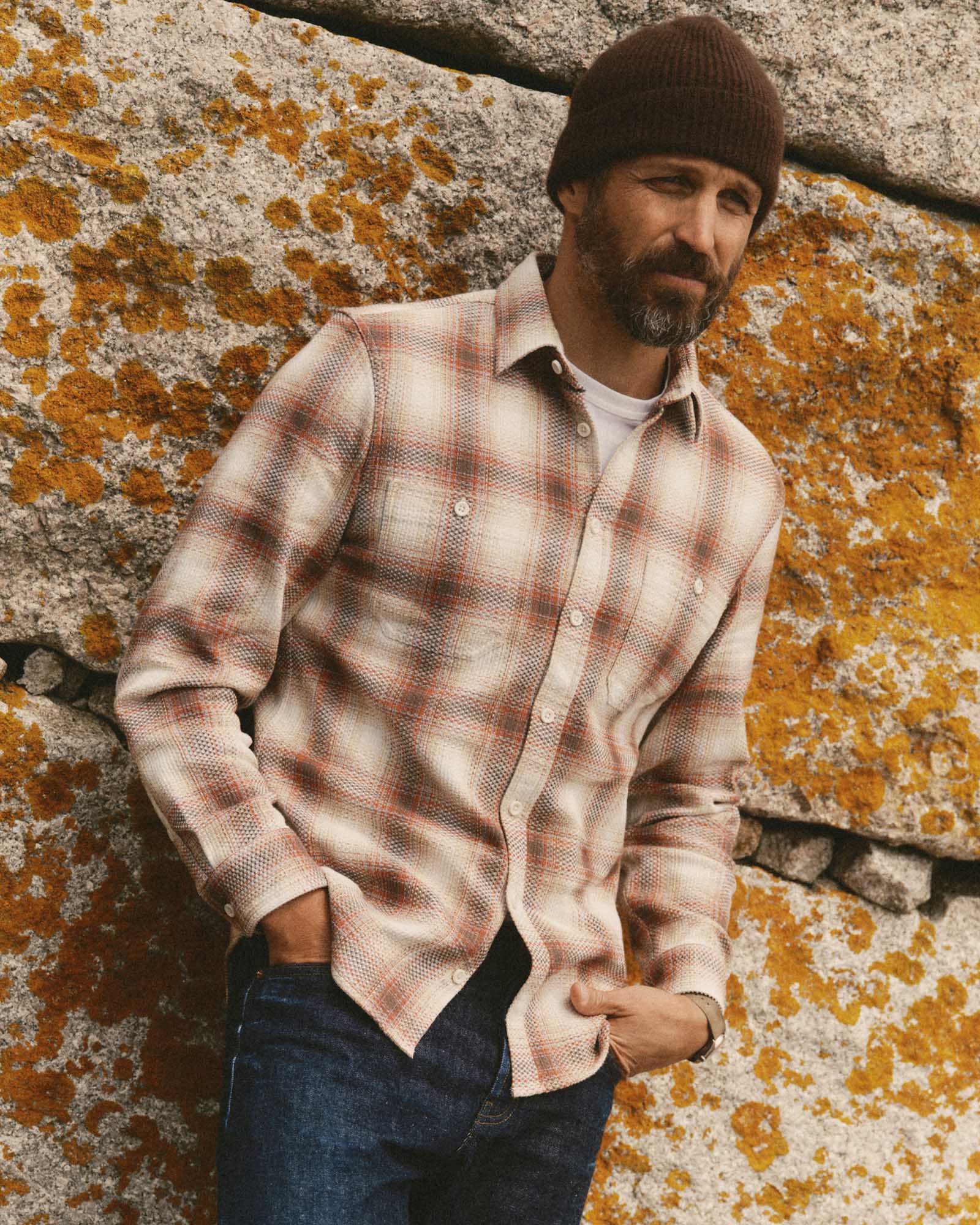 fit model leaning against the wall wearing The Utility Shirt in Seaside Check Sashiko, Wovens by Taylor Stitch