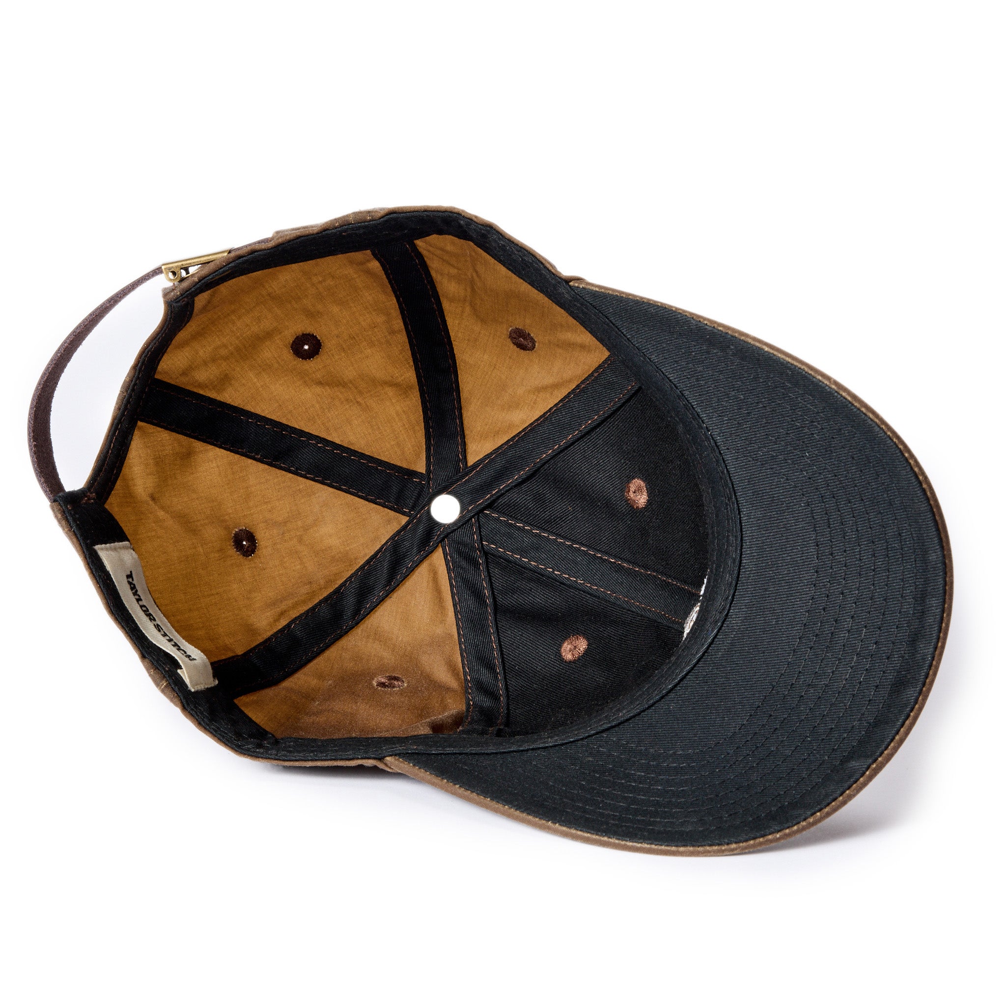 flatlay of The Ball Cap in Dark Khaki Waxed Canvas, showing the underside of the hat, Accessories by Taylor Stitch