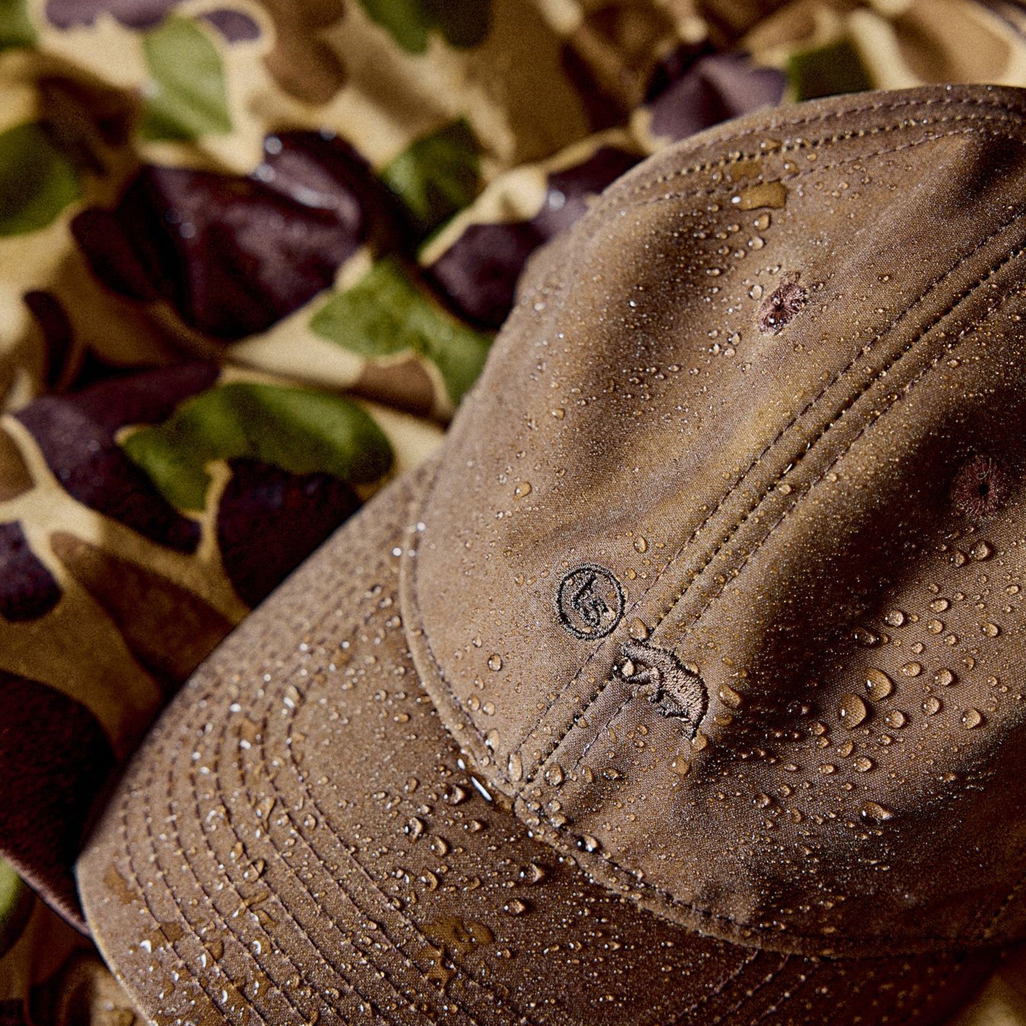 The Ball Cap in Dark Khaki Waxed Canvas with water droplets on it, Accessories by Taylor Stitch