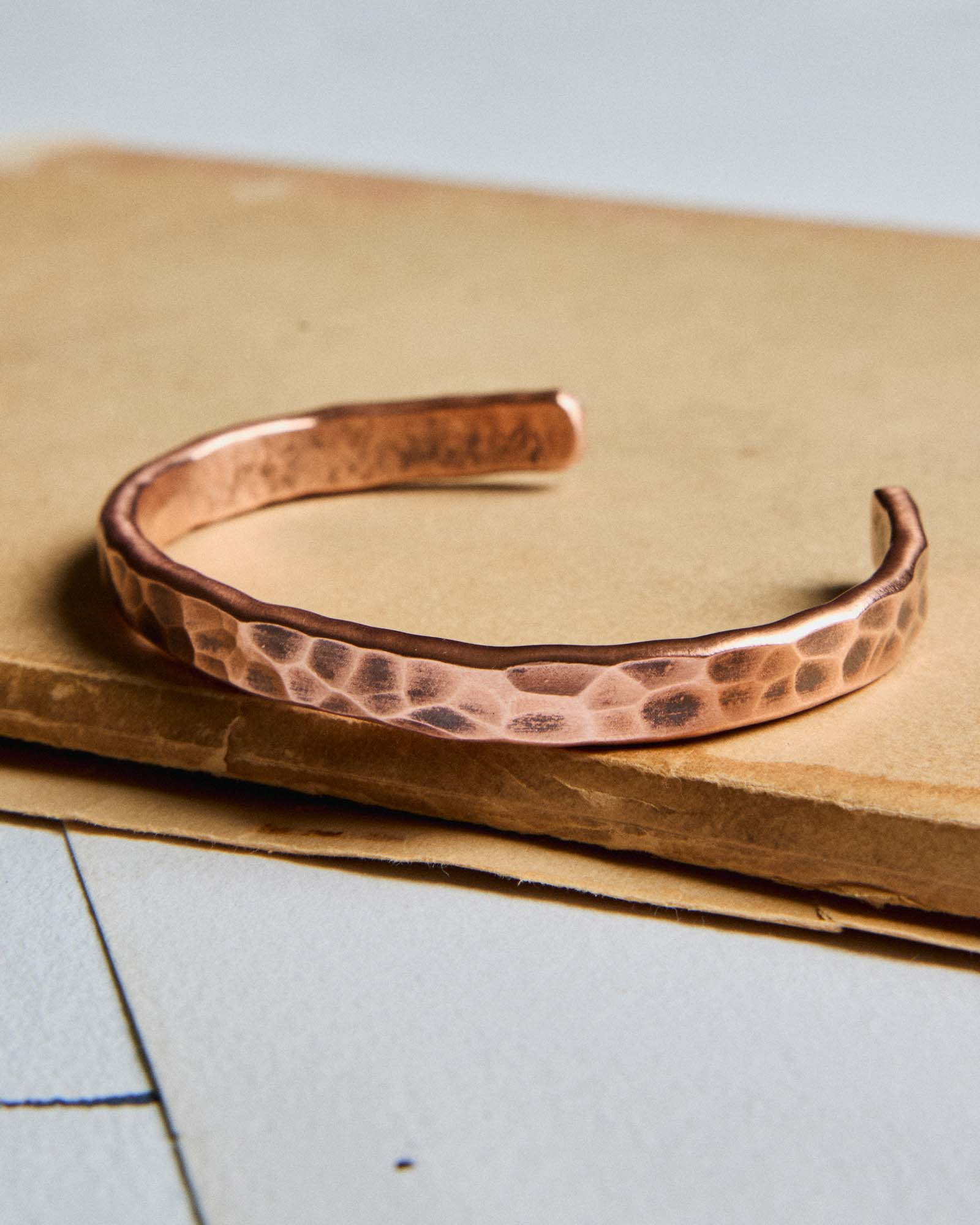 editorial image of The Hammered Cuff in Copper on a piece of paper, Accessories by Taylor Stitch