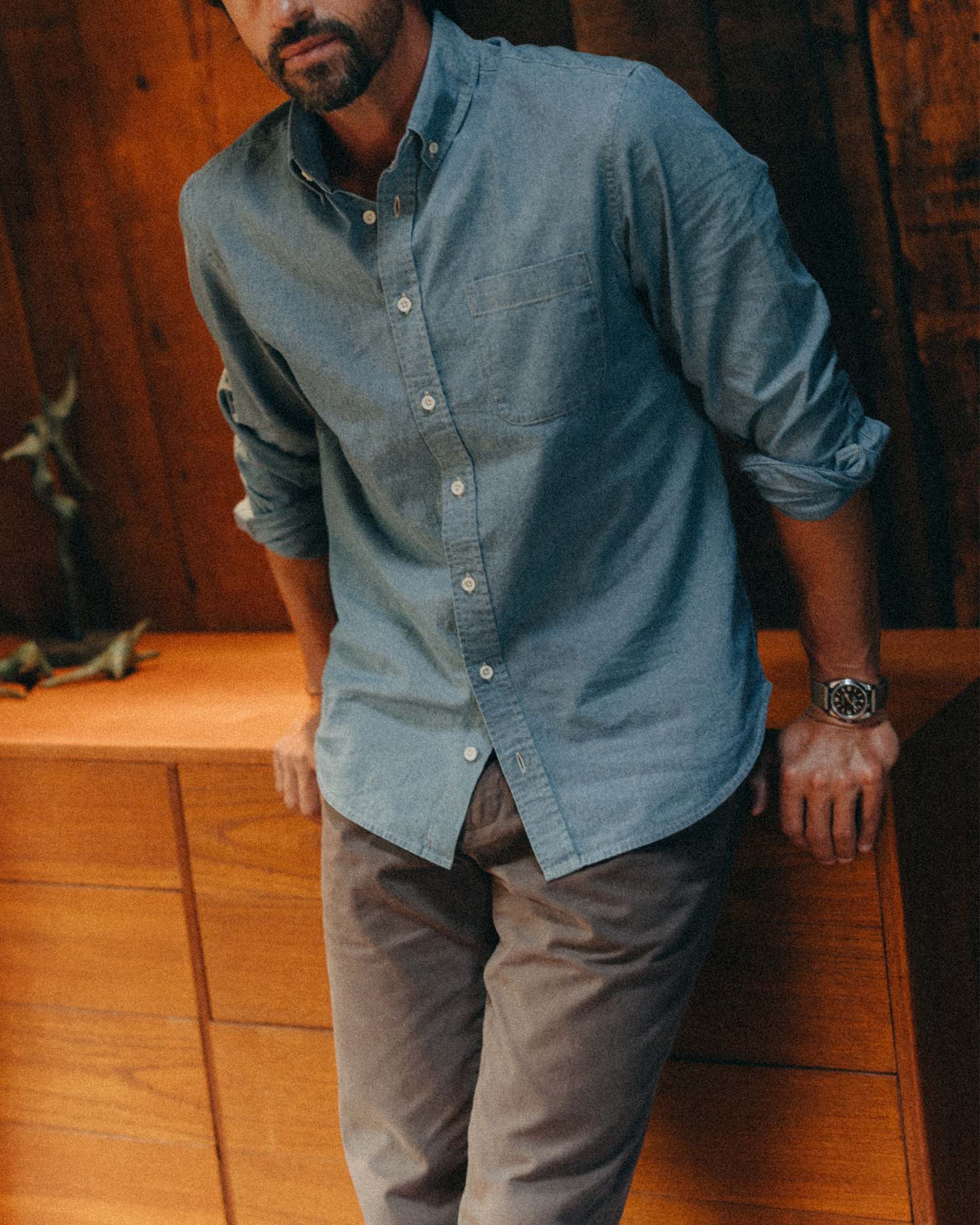fit model leaning against a dresser wearing The Jack in Washed Indigo Chambray, Wovens by Taylor Stitch