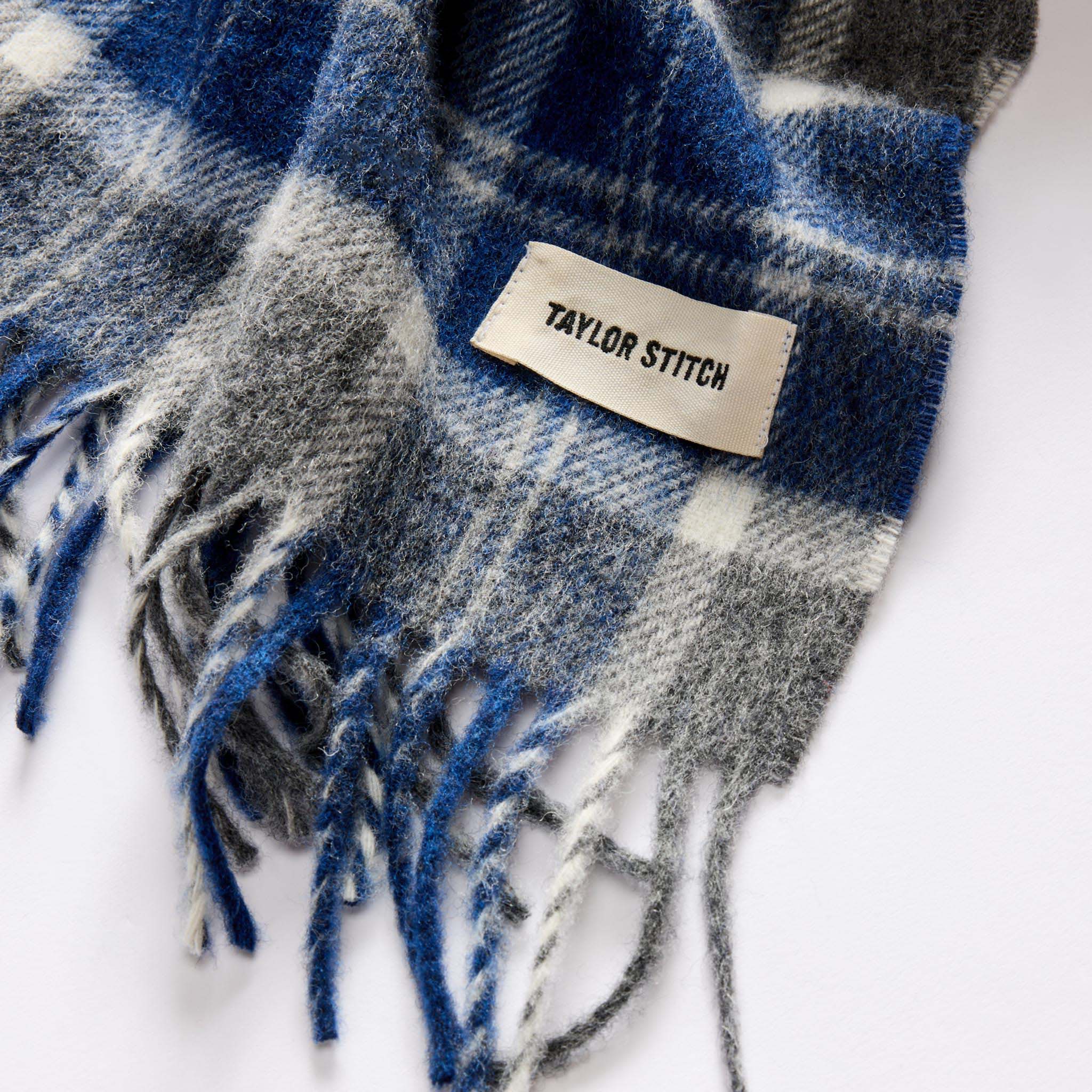 material shot of the TS label on The Fireside Scarf in Blue Check Merino, Accessories by Taylor Stitch