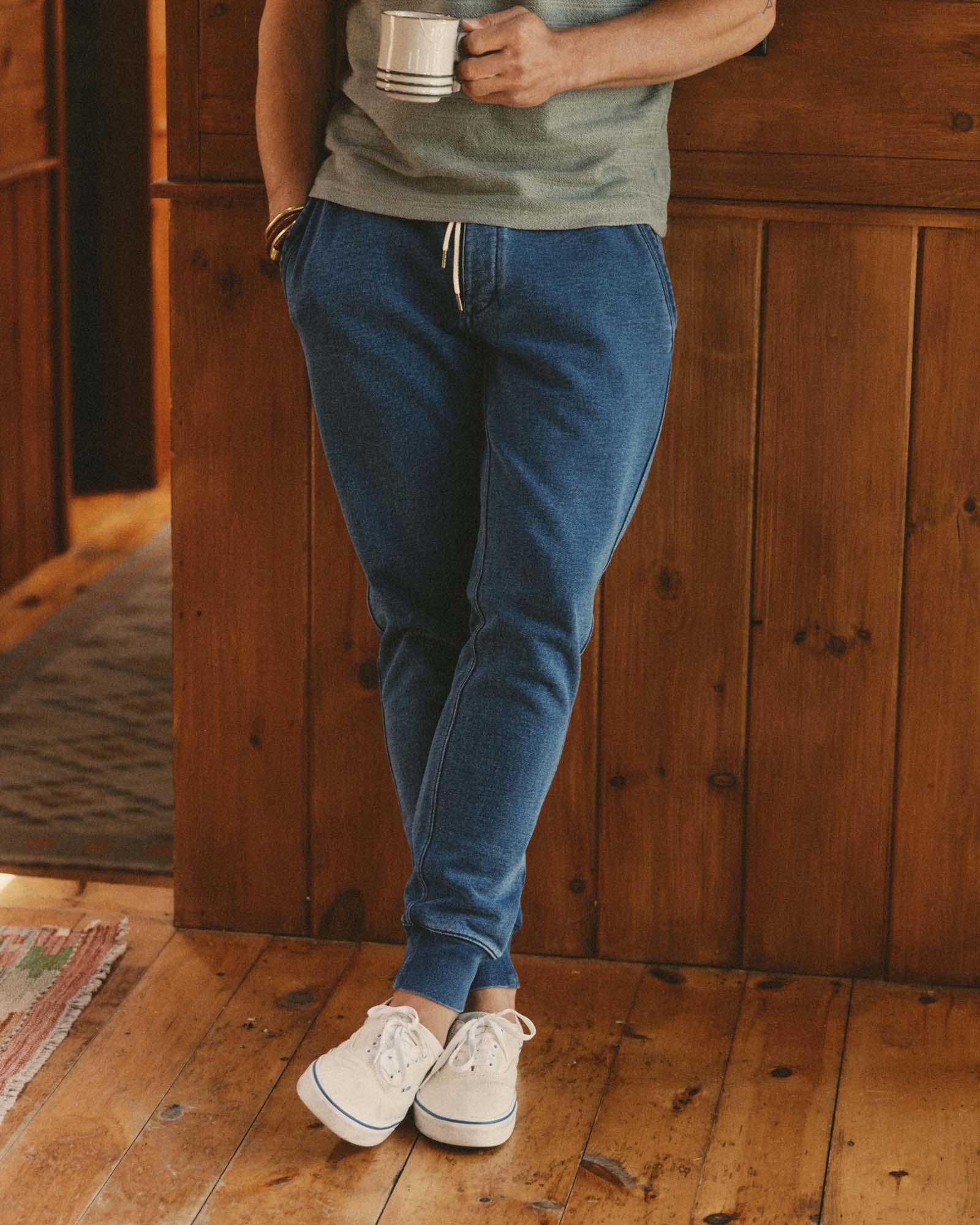 fit model leaning against the wall wearing The Sunset Pant in Washed Indigo Terry, Bottoms by Taylor Stitch