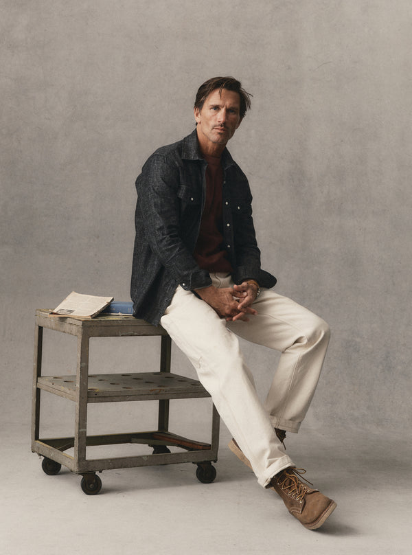 fit model sitting wearing The Glacier Shirt in Black Indigo Hemp Denim