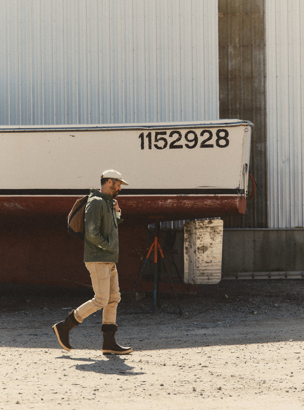 fit model walking wearing The Hatteras Anorak in Fatigue Olive Dry Wax