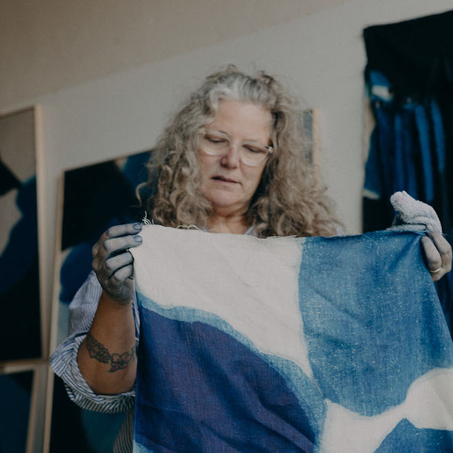 Carrie Crawford of Mineral Workshop holding up one of her natural-dyed fabrics.