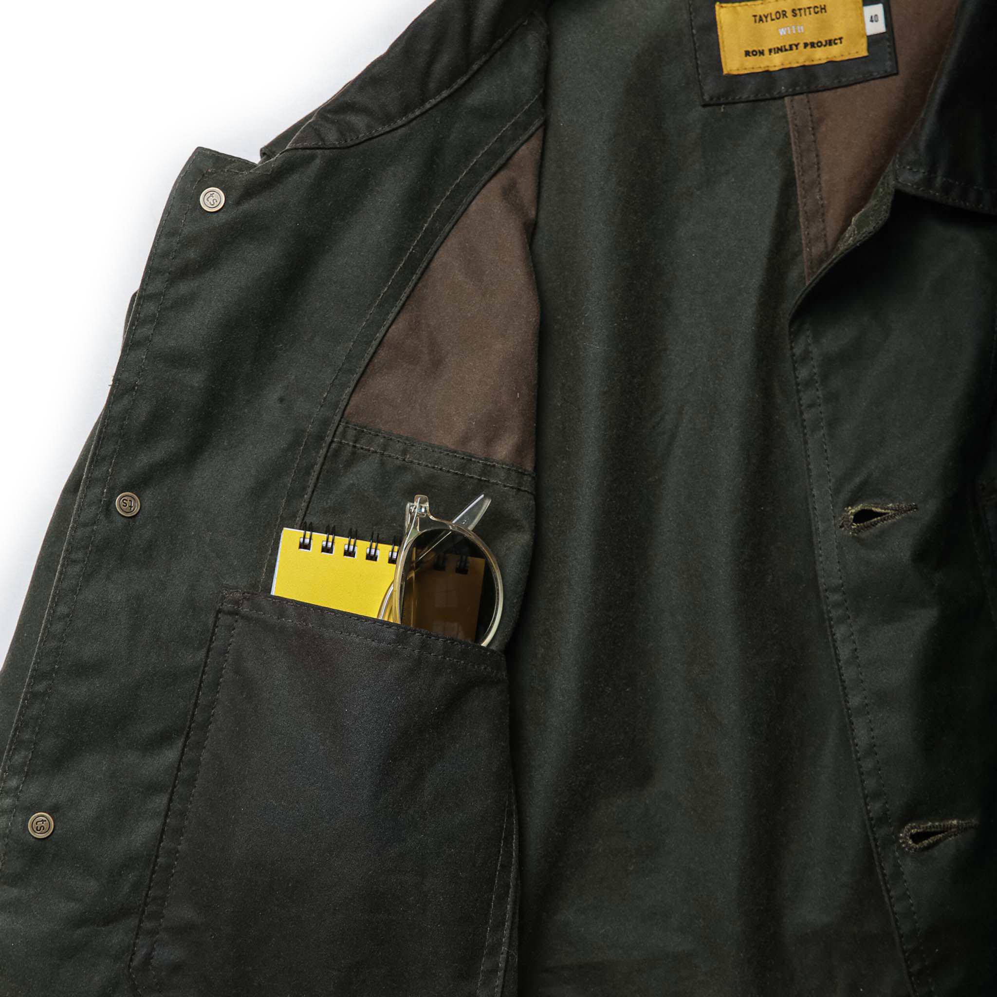 material shot of personal items in inside chest pocket of The Task Jacket in Waxed Khaki and Olive Patchwork, Outerwear by Taylor Stitch