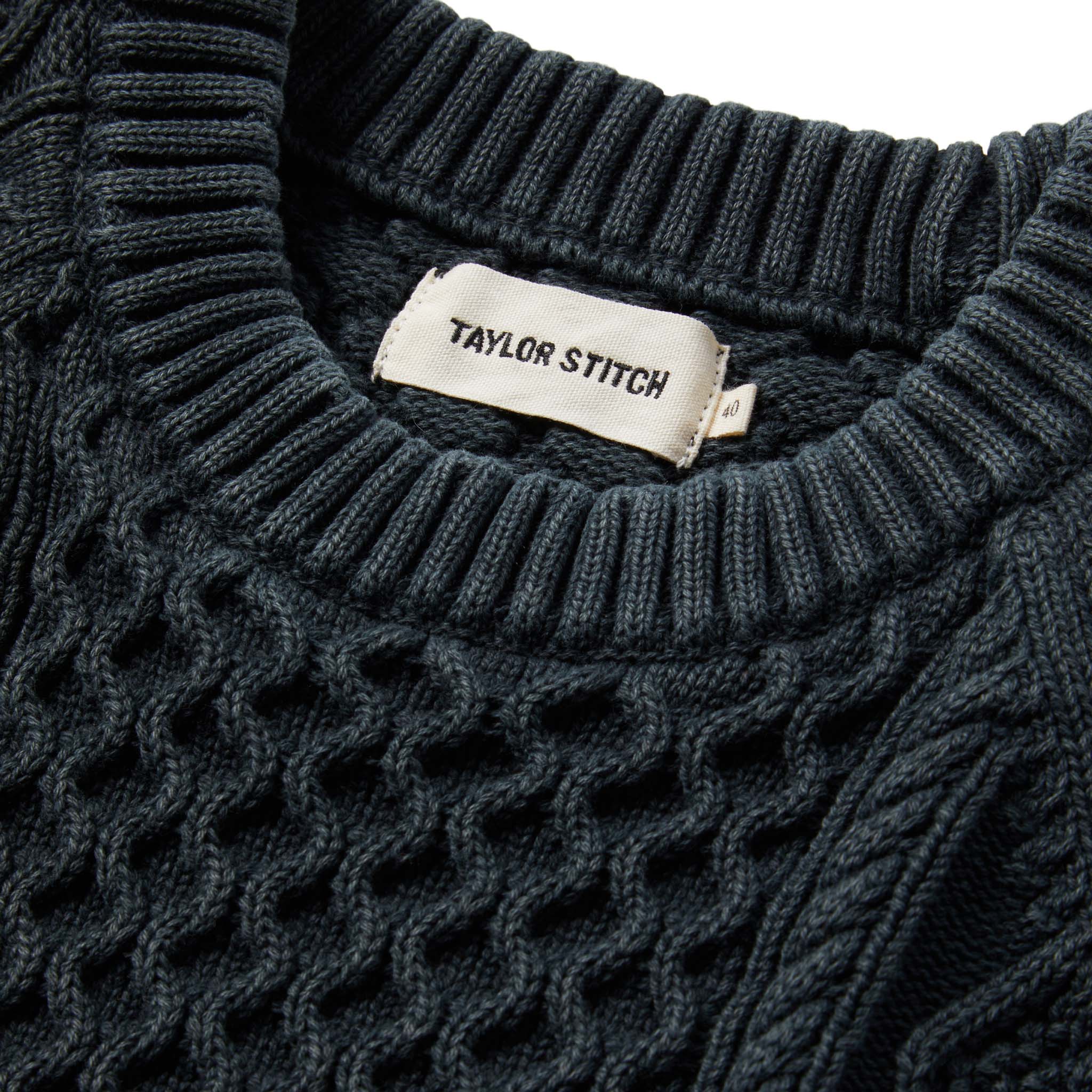 material shot of The Orr Sweater in Charcoal showing interior label, Knits by Taylor Stitch